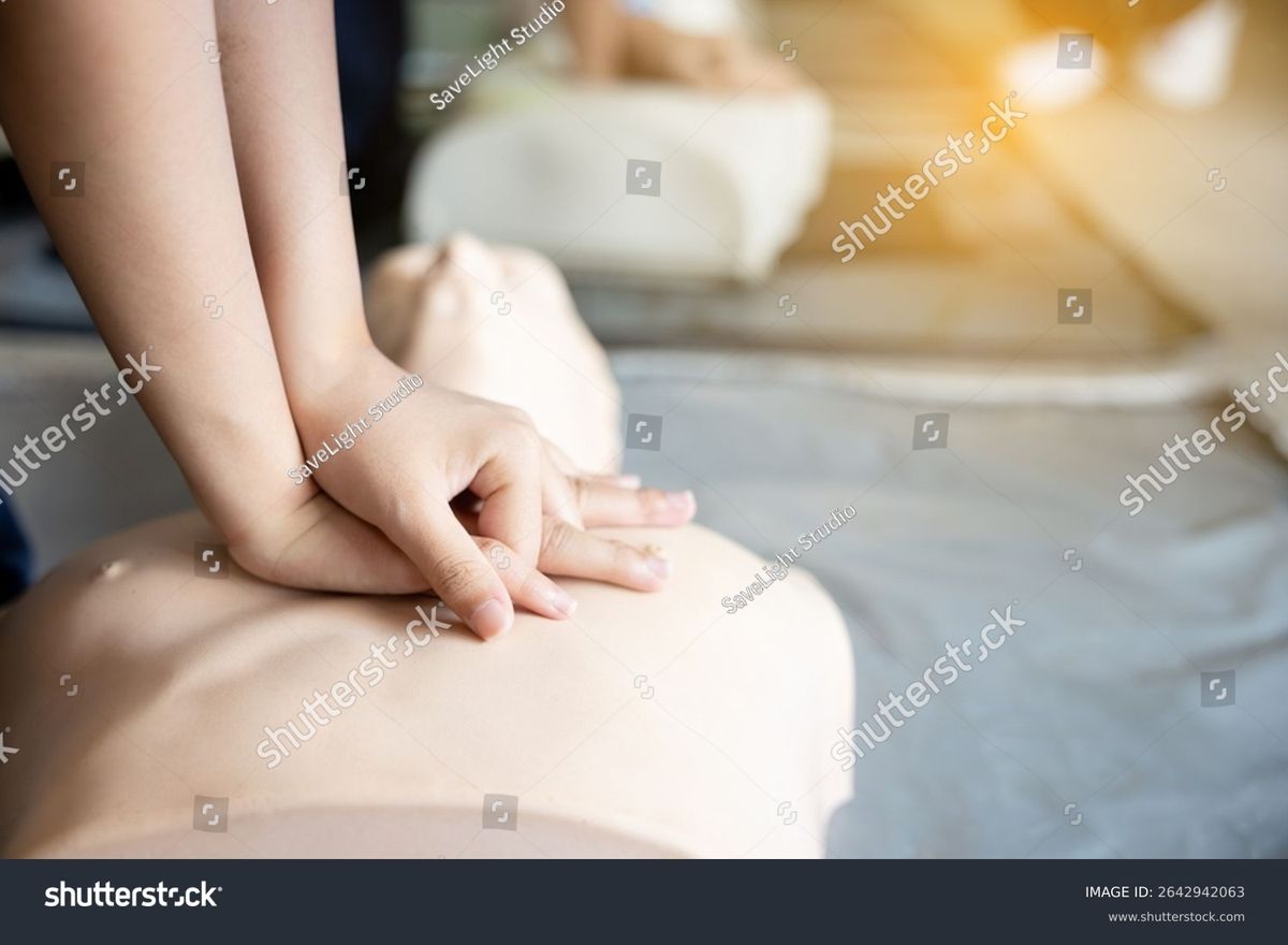Close-up of hands practicing chest compressions on an AHA CPR training manikin