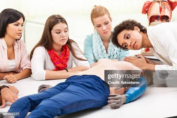 Instructor demonstrating CPR techniques to a small class